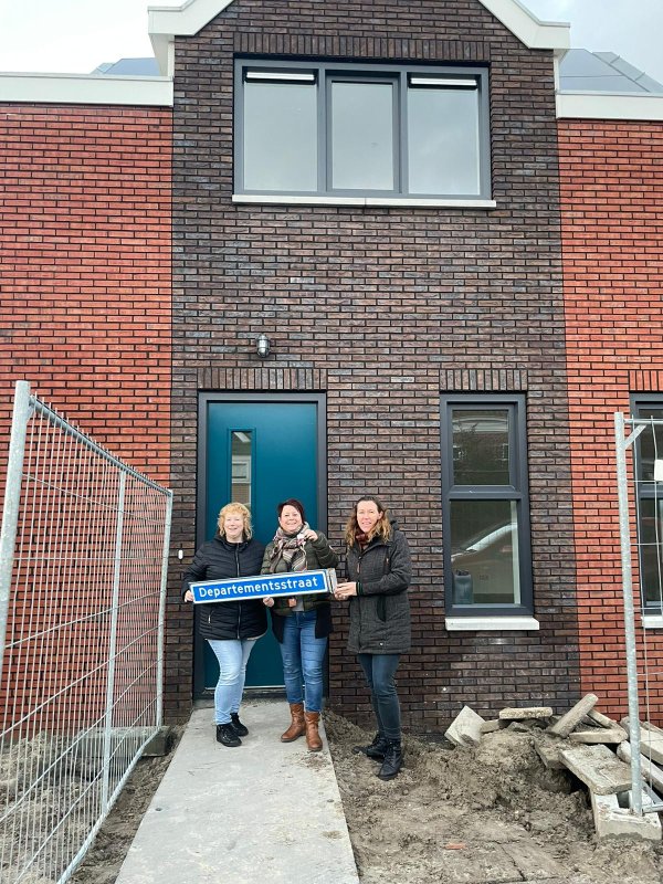 Bewoners met straatnaambord voor nieuwe woningen Departemenstraat